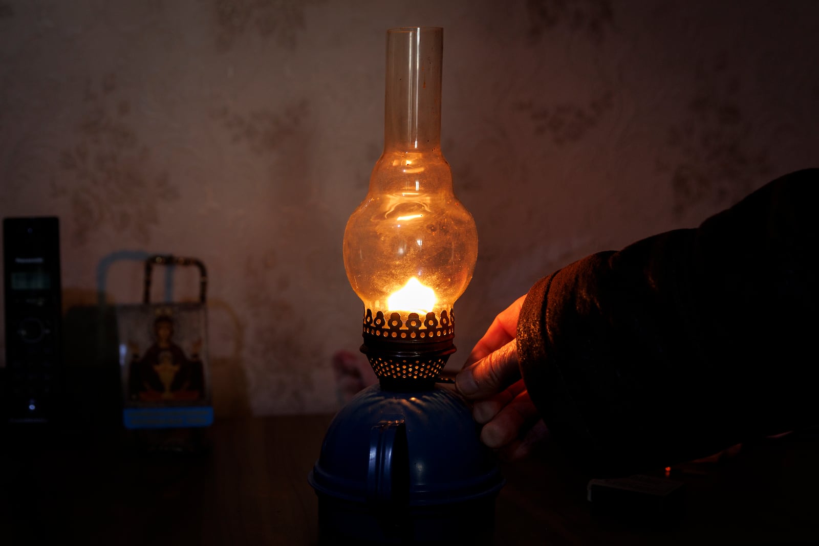 Retired teacher Vasile Donici lights a gas lamp in his home in Copanca, Moldova, Wednesday, Jan. 8, 2025. (AP Photo)