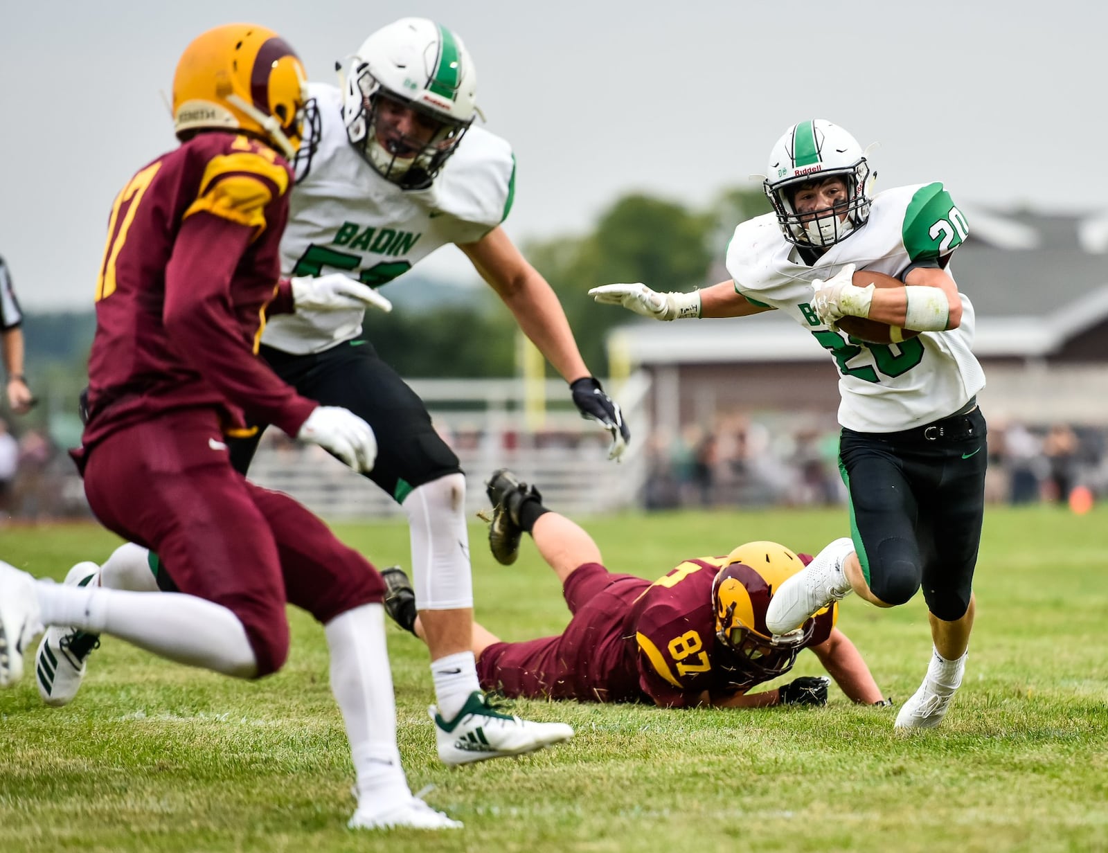 Badin’s Alex DeLong (20) carries the ball and eludes Ross defenders during Friday night’s game at Robinson Field in Ross Township. NICK GRAHAM/STAFF