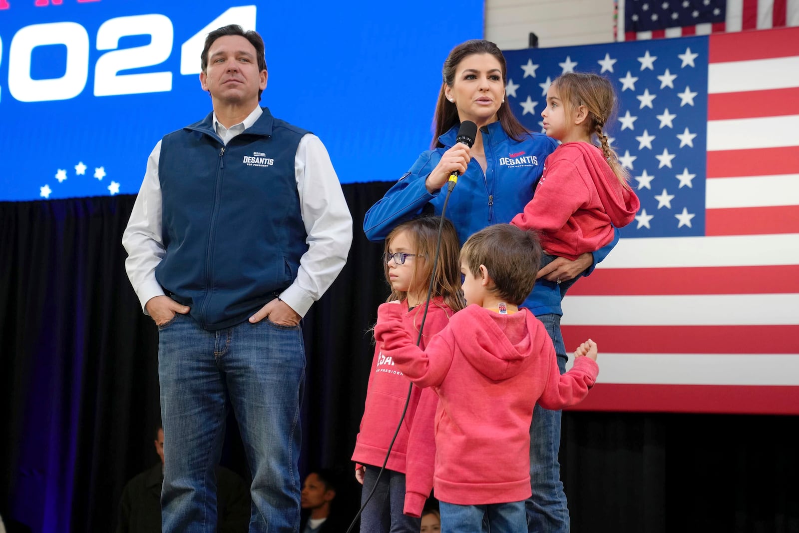 FILE - Republican presidential candidate Florida Gov. Ron DeSantis, left, looks on as his wife Casey DeSantis, carrying daughter Mamie, speaks during a campaign event at The Hangout on Saturday, Jan. 20, 2024, in Myrtle Beach, S.C. Standing in foreground are DeSantis' children Madison, left, and Mason. (AP Photo/Meg Kinnard, File)