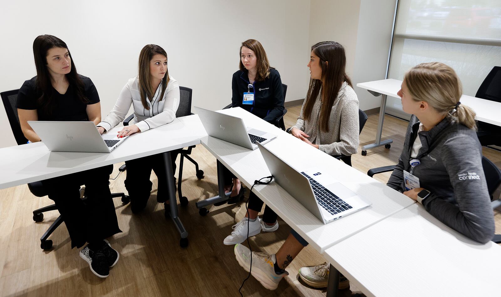 Premier Health nurse practitioners Sara Wilson-Rector (second from left) and Marylou O'Brien (middle) provide feedback to nurse practitioner Delani Deckard (far left), as well as to physician assistants Ashley Barr (second from right) and Emily Malsch (far right), as part of the Premier Health Primary Care Residency, which is a three-month onboarding program for the new providers. MARSHALL GORBY\STAFF