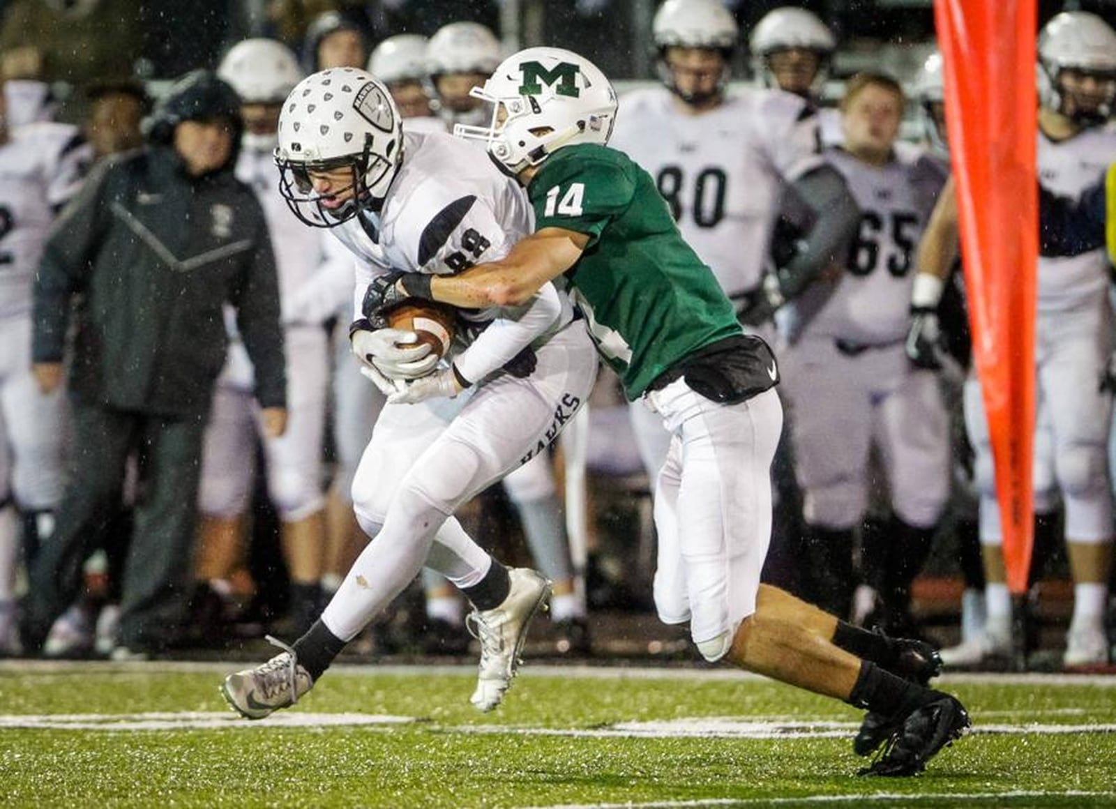 Lakota East’s Evan Yablonsky is wrapped up by Mason’s Jaydon Kaufhold during a 20-17 victory by East in a Division I, Region 4 playoff game at Dwire Field in Mason. NICK GRAHAM/STAFF