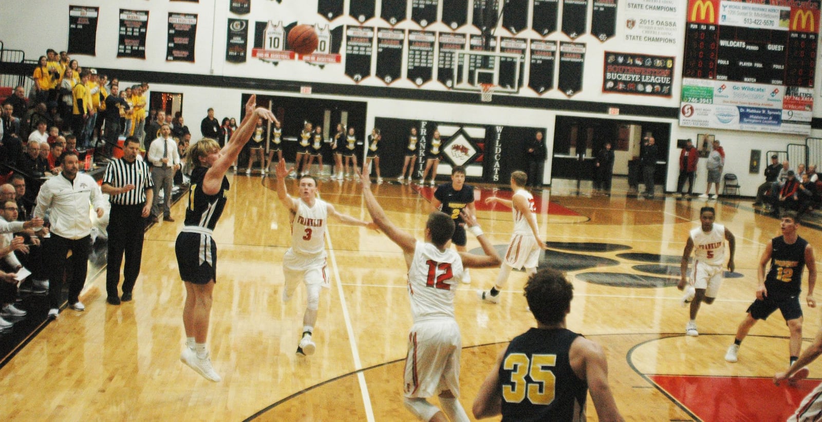 Monroe’s Nick Alfrey (11) launches a shot as Franklin’s Zack Minton (3) and Braden Woods (12) close in Tuesday night at Darrell Hedric Gym in Franklin. The host Wildcats won 67-42. RICK CASSANO/STAFF