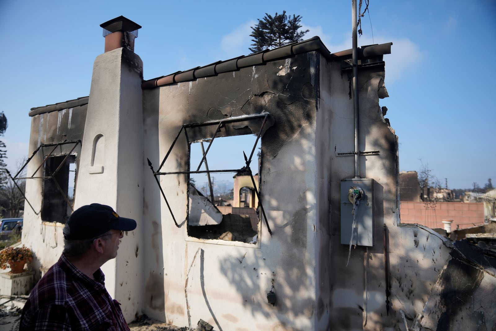 Joel Parkes, a teacher at Los Angeles Unified School District returns to his destroyed home in the aftermath of the Eaton Fire, Sunday, Jan. 19, 2025, in Altadena, Calif. (AP Photo/Damian Dovarganes)