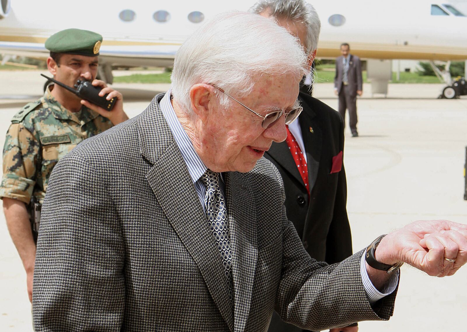 FILE - Former U.S. President Jimmy Carter looks at his watch upon arriving at Queen Alia International airport in Amman ,Jordan, on April 20, 2008. Earlier on his Middle East tour, Carter met with exiled Hamas leader Khaled Meshaal despite strong opposition from Israel and the White House. (AP Photo/Jamal Nasrallah, Pool, File)