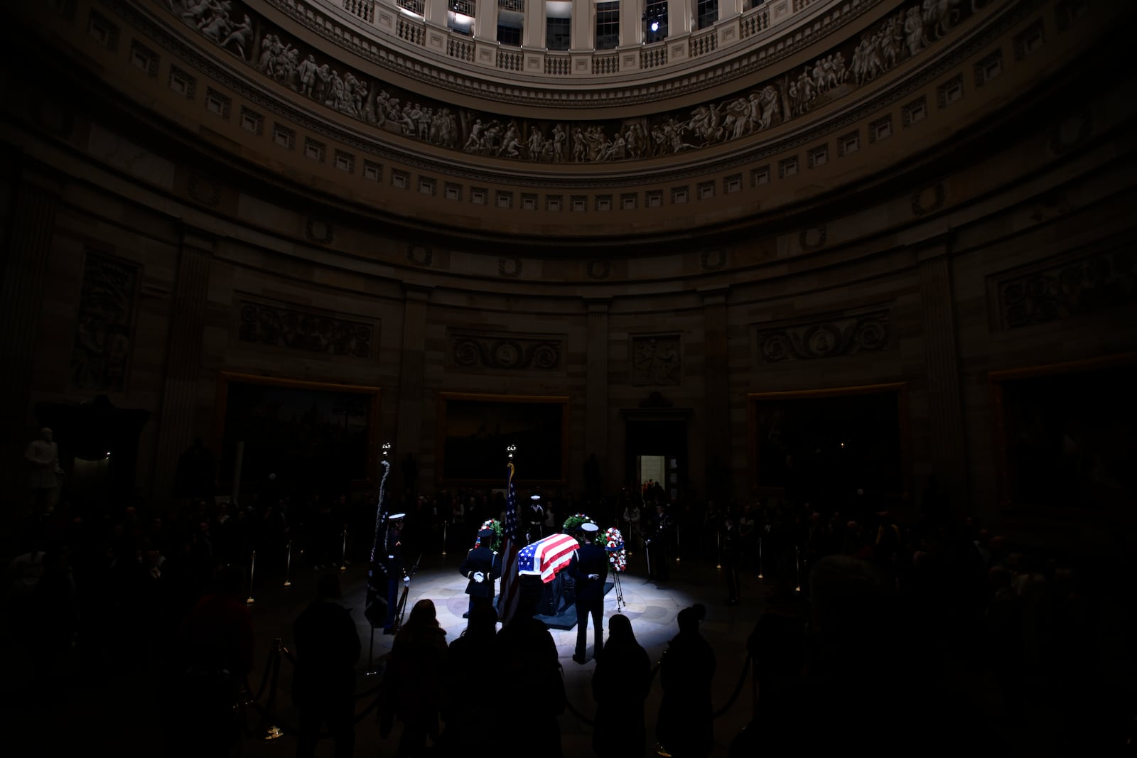 A spotlight iluminates the flag-draped casket to pay tribute toformer President Jimmy Carter as he lies in state at the Rotunda of the U.S. Capitol on Tuesday, Jan. 7, 2025, in Washington. (AP Photo/John McDonnell)