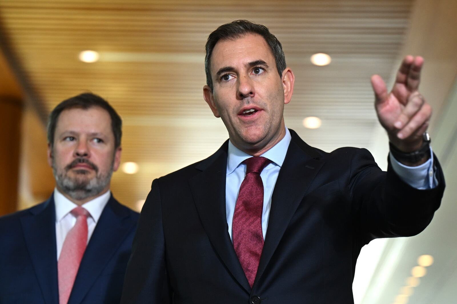 Australian Treasurer Jim Chalmers, right, gestures as he and Industry Minister Ed Husic speak to the media during a press conference at Parliament House in Canberra, Friday, Nov. 22, 2024. (Lukas Coch/AAP Image via AP)