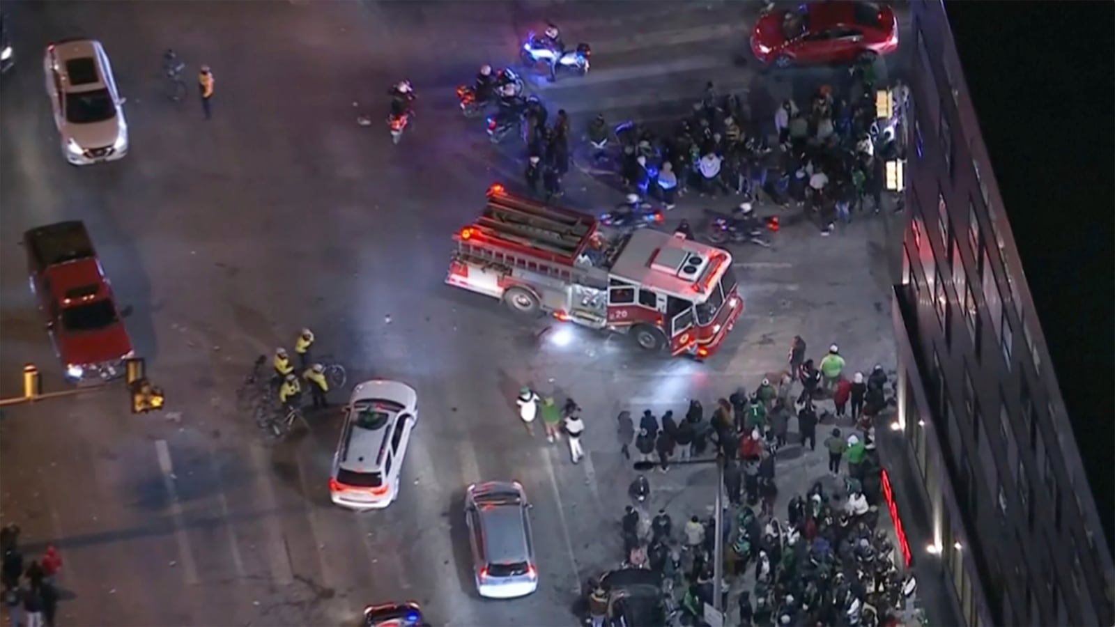 In this image from a video, first responders work near the scene after a car, police said, hit and injured pedestrians in a crowd of people that was leaving the Philadelphia Eagles playoff game, as bystanders gather on a street in Philadelphia Sunday, Jan. 26, 2025. (WPVI-TV/6ABC via AP)