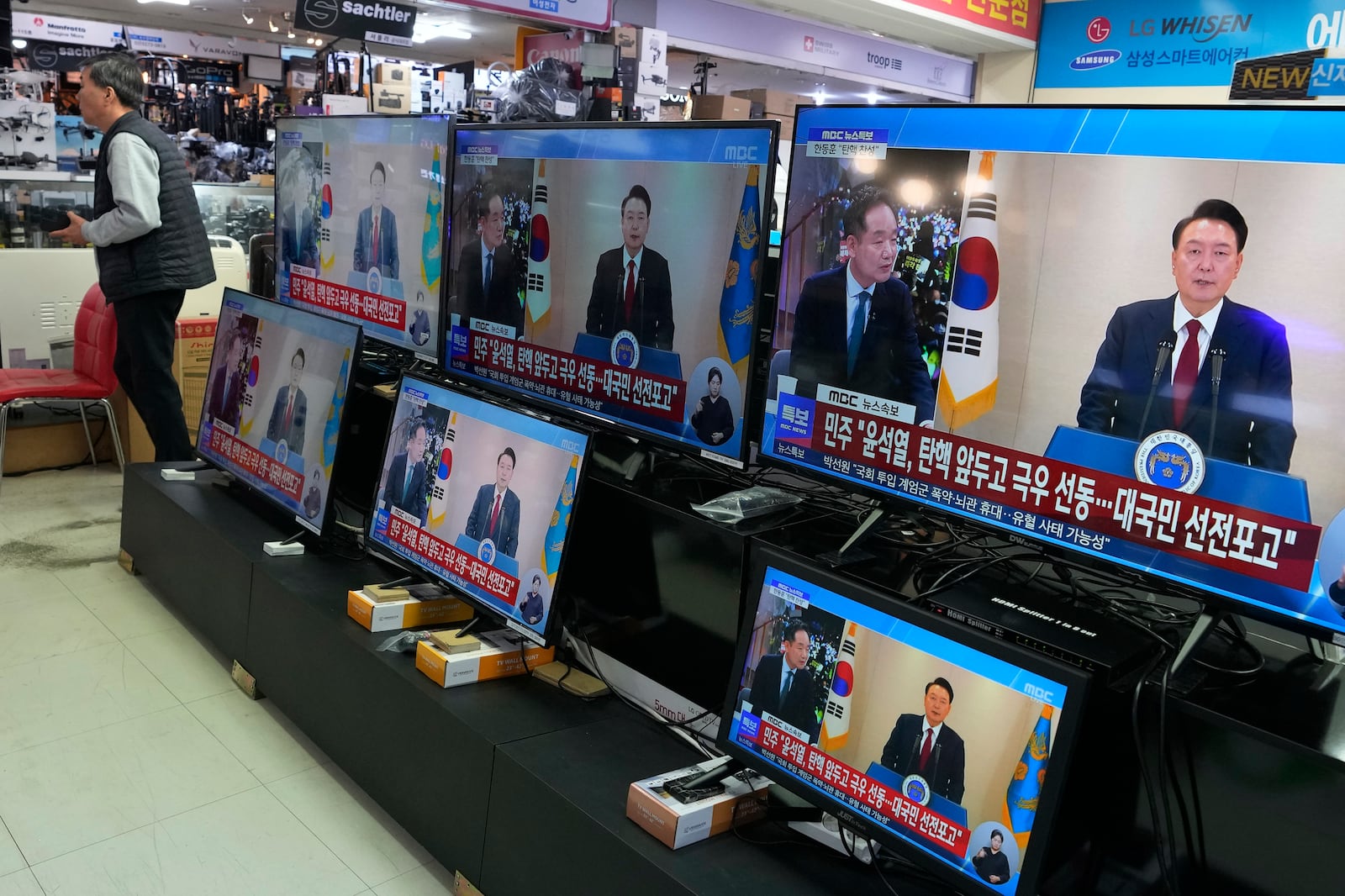 TV screens show the broadcast of South Korean President Yoon Suk Yeol's speech at the Yongsan Electronic store in Seoul, South Korea, Thursday, Dec. 12, 2024. (AP Photo/Ahn Young-joon)