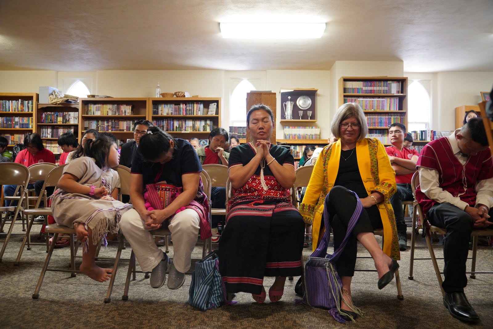 May Htoo, center, prays during a Karen-language service at Indian lake Baptist Church in Worthington, Minn., on Sunday, Oct. 20, 2024. (AP Photo/Jessie Wardarski)