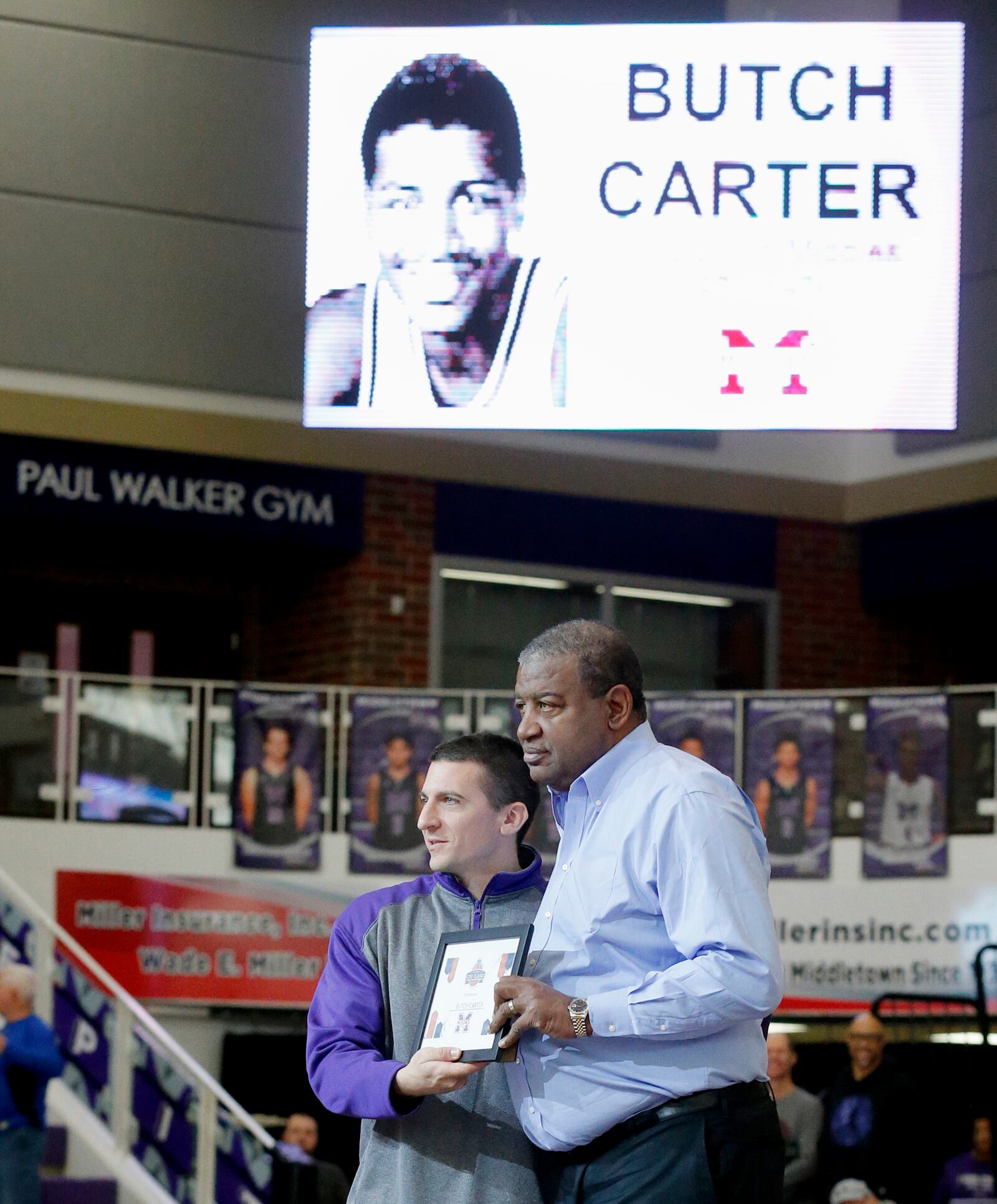 Butch Carter, right, was recognized by Middletown Athletic Director Aaron Zupka at halftime of the 2019 Crestwood-Middletown game during the Midwest King Classic at Jerry Lucas Court in Wade E. Miller Arena in Middletown. FILE PHOTO