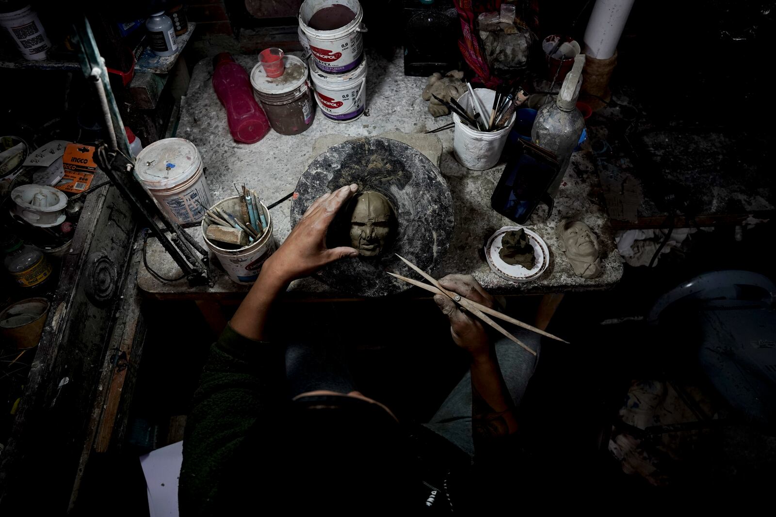 Artisan William Luna creates a mask of a real person to adorn tantawawa, a sweet bread traditional for Day of the Dead celebrations, in La Paz, Bolivia, Thursday, Oct. 31, 2024. (AP Photo/Freddy Barragan)