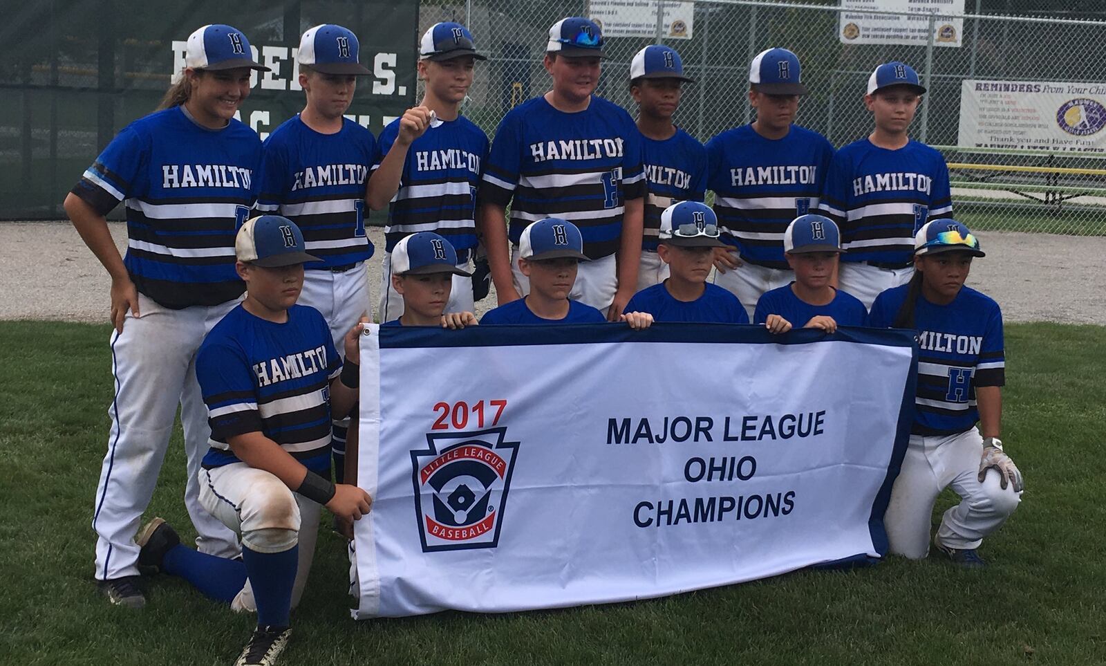 Hamilton West Side’s players pose with the Ohio Little League 12-year-old baseball championship banner Saturday after beating Canfield 15-4 in the title game at Ford Park’s Robert S. Hoag Field in Maumee. RICK CASSANO/STAFF