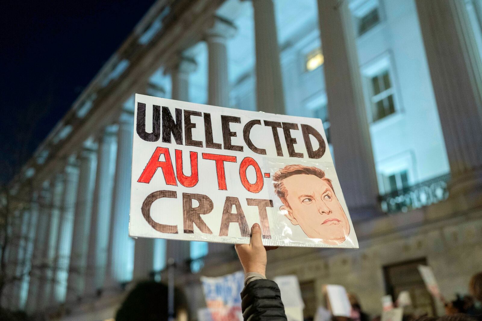 People protest during a rally against Elon Musk outside the Treasury Department in Washington, Tuesday, Feb. 4, 2025. (AP Photo/Jose Luis Magana)