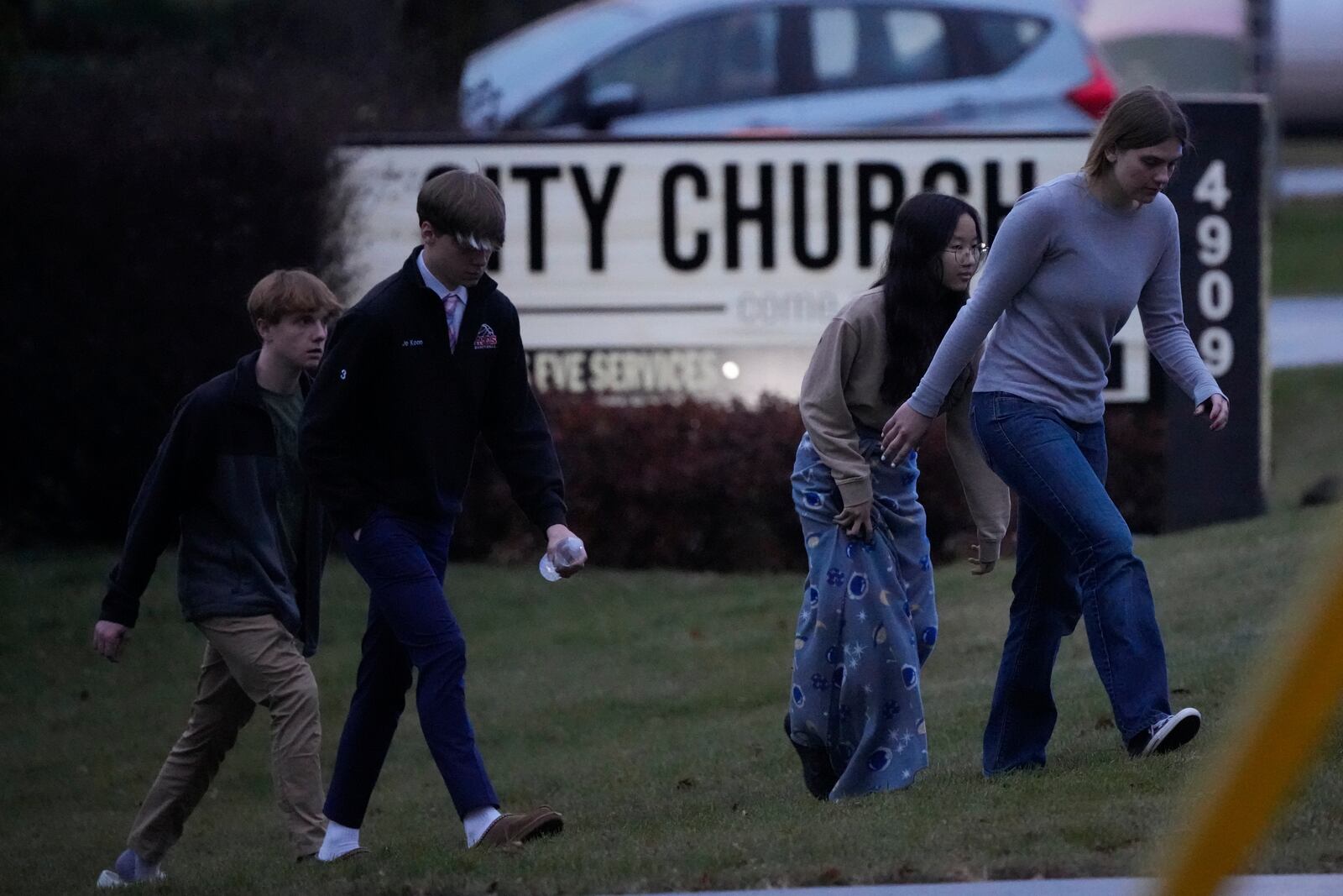 Students walk to a bus as they leave the shelter following a shooting at the Abundant Life Christian School, Monday, Dec. 16, 2024. (AP Photo/Morry Gash)