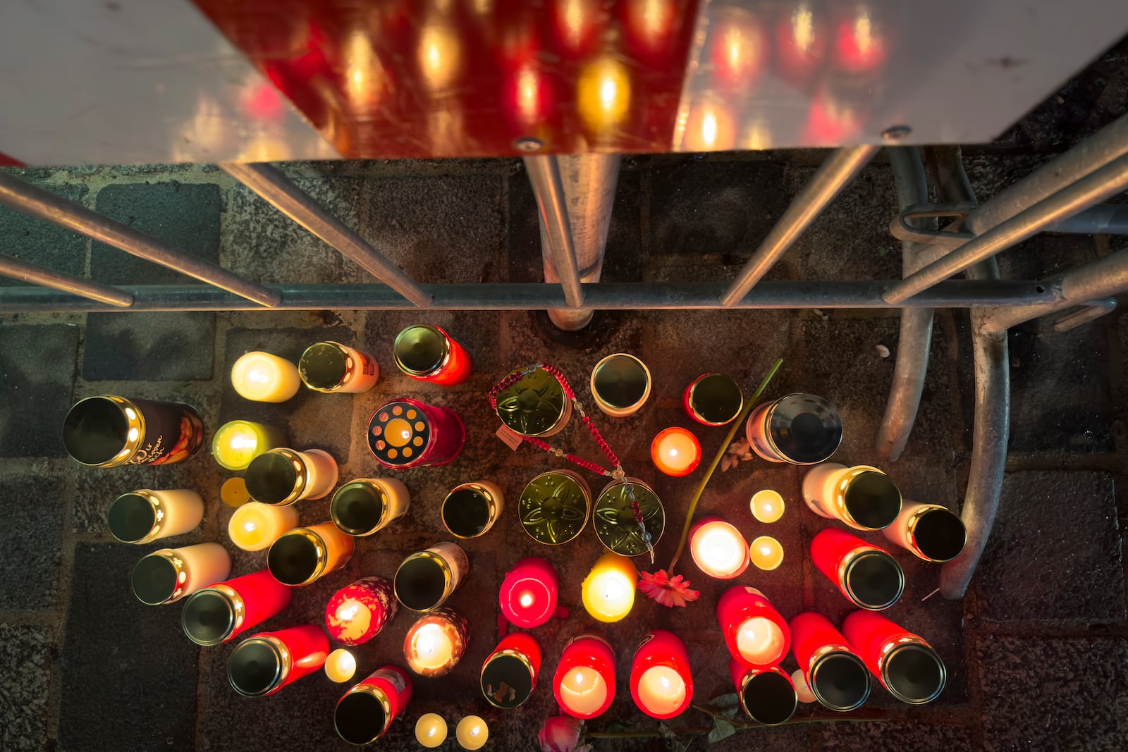 Candles are lit at the site of a stabbing attack in Villach, Austria, Sunday, Feb. 16, 2025. (AP Photo/Darko Bandic)