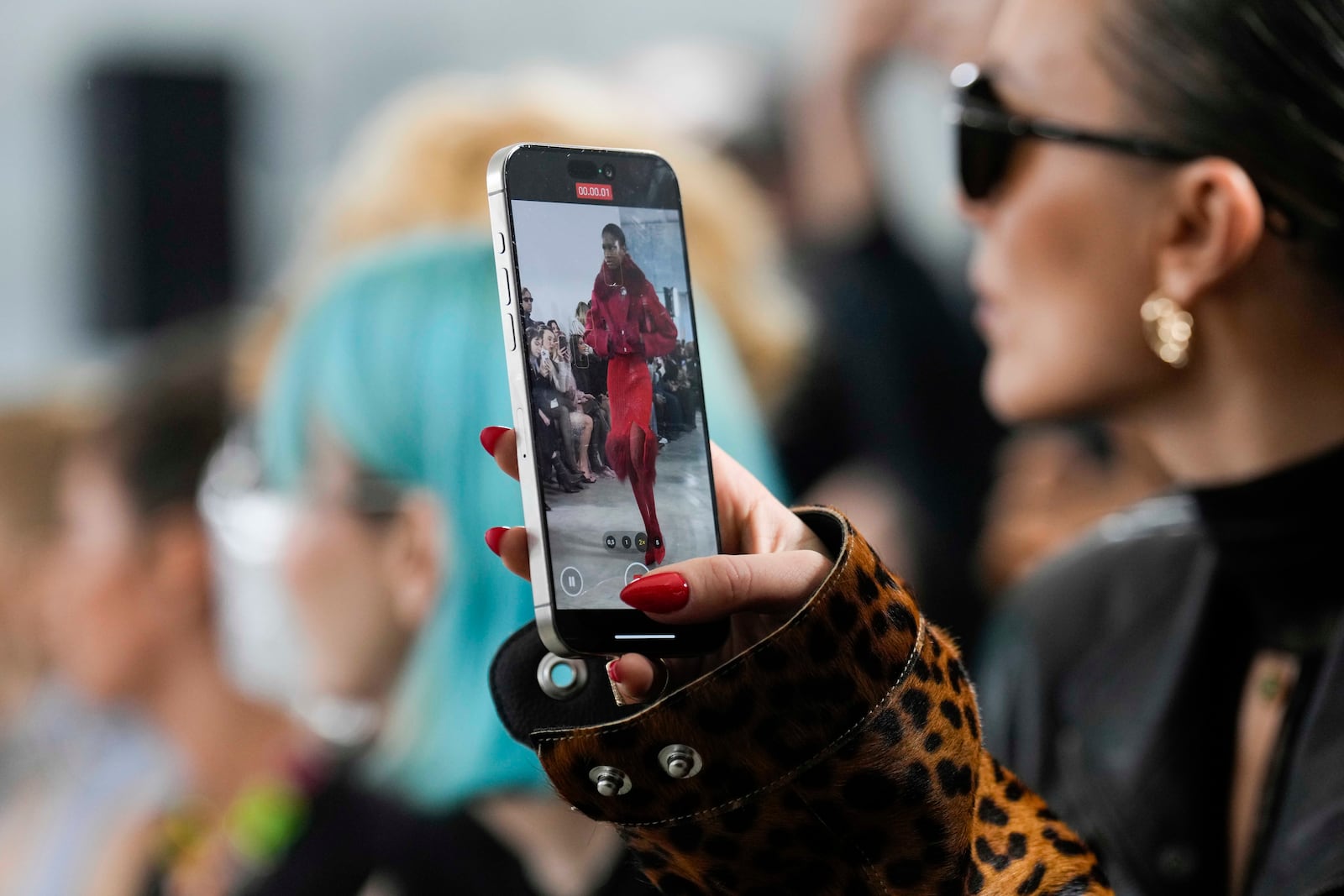 A guest takes video during the Blumarine Fall/Winter 2025-2026 Womenswear fashion show, presented in Milan, Italy, Thursday, Feb. 27, 2025. (AP Photo/Luca Bruno)