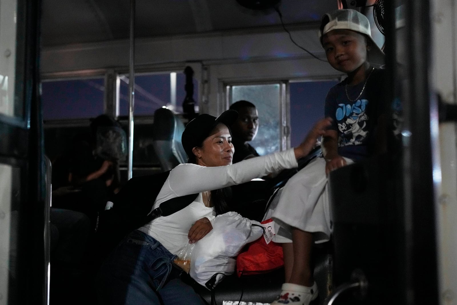 A Vietnamese woman and her son arrive with other migrants in Panama City on Saturday, March 8, 2025, after spending weeks in a Panamanian immigration camp following their deportation from the U.S. and being released on the condition that they leave the country within 30 days. (AP Photo/Matias Delacroix)