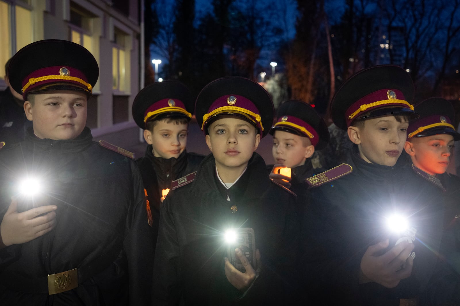 Cadets turn on their flashlights to commemorate 659 Ukrainian children, who were killed during the war with Russia, in a military lyceum on World Children's Day in Kyiv, Ukraine, Wednesday, Nov. 20, 2024. (AP Photo/Efrem Lukatsky)