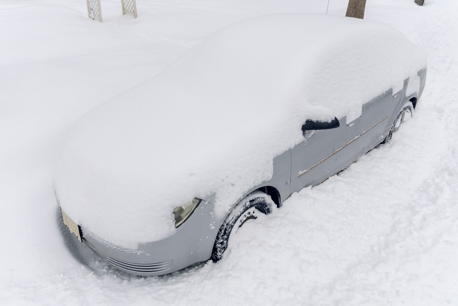 A vehicle sits buried in snow and plowed in by city trucks on Thursday, Feb. 13, 2025 in Lapeer, Mich. ( Jake May/The Flint Journal via AP)