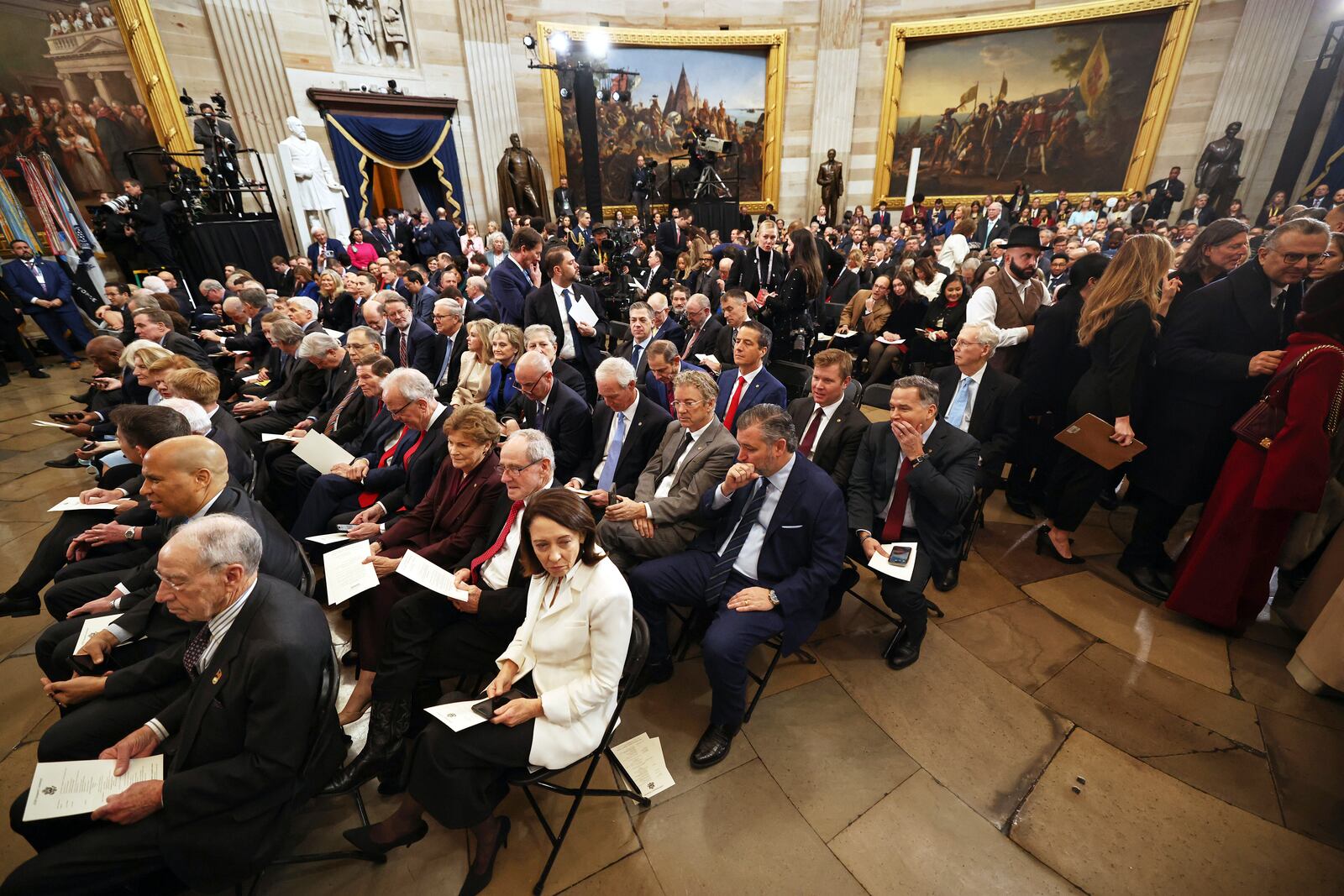 People sit before the 60th Presidential Inauguration in the Rotunda of the U.S. Capitol in Washington, Monday, Jan. 20, 2025. (Chip Somodevilla/Pool Photo via AP)