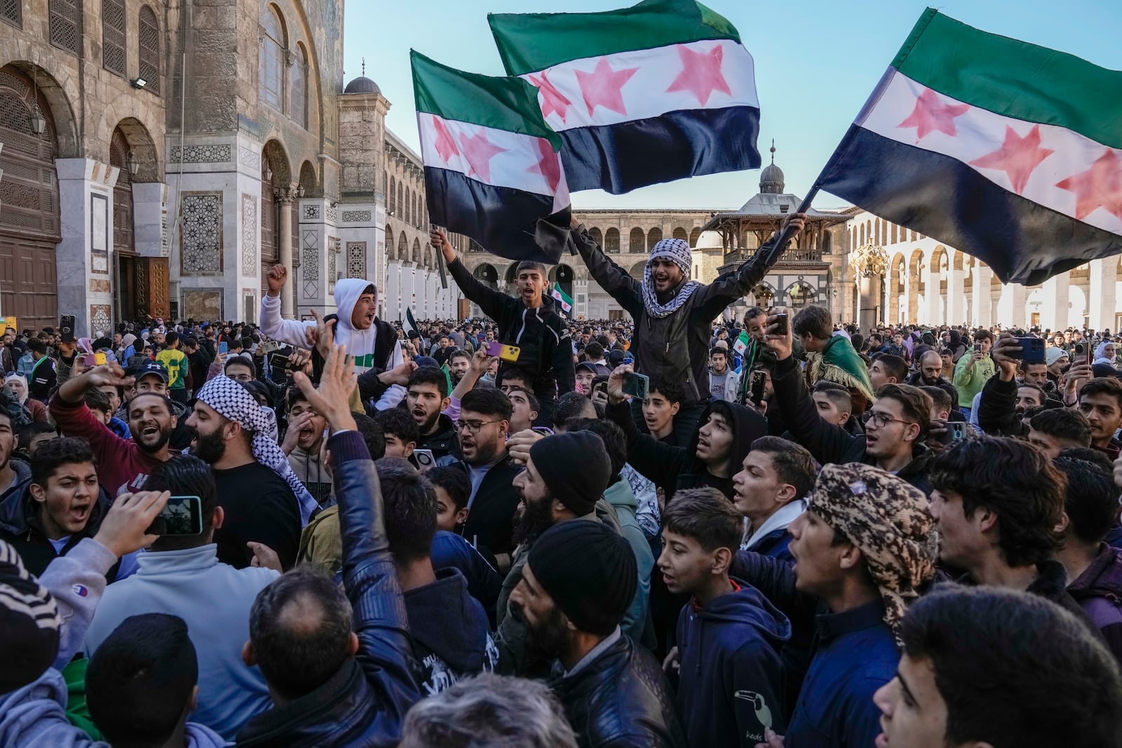 FILE - Demonstrators chant slogans and wave the new Syrian flag as they gather for Friday prayers at the Umayyad mosque in Damascus, Syria, Friday, Dec. 13, 2024. (AP Photo/Leo Correa, File)