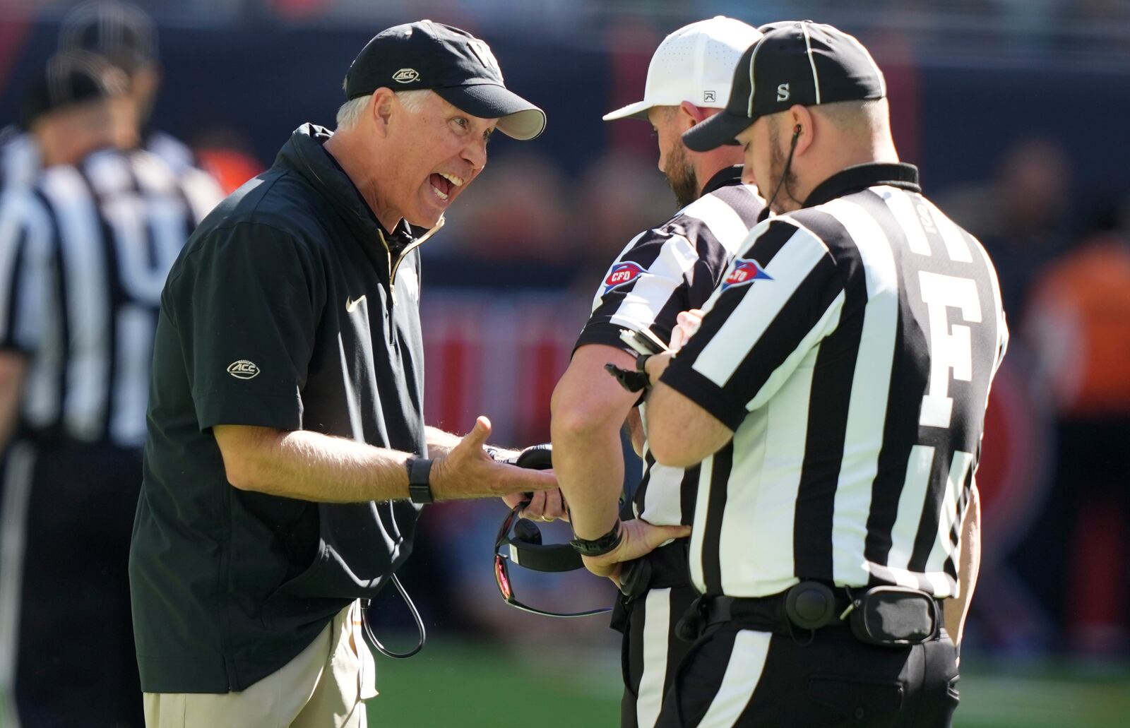 Wake Forest head coach Dave Clawson, left, talks with officials during the first half of an NCAA college football game against Miami, Saturday, Nov. 23, 2024, in Miami Gardens, Fla. (AP Photo/Lynne Sladky)