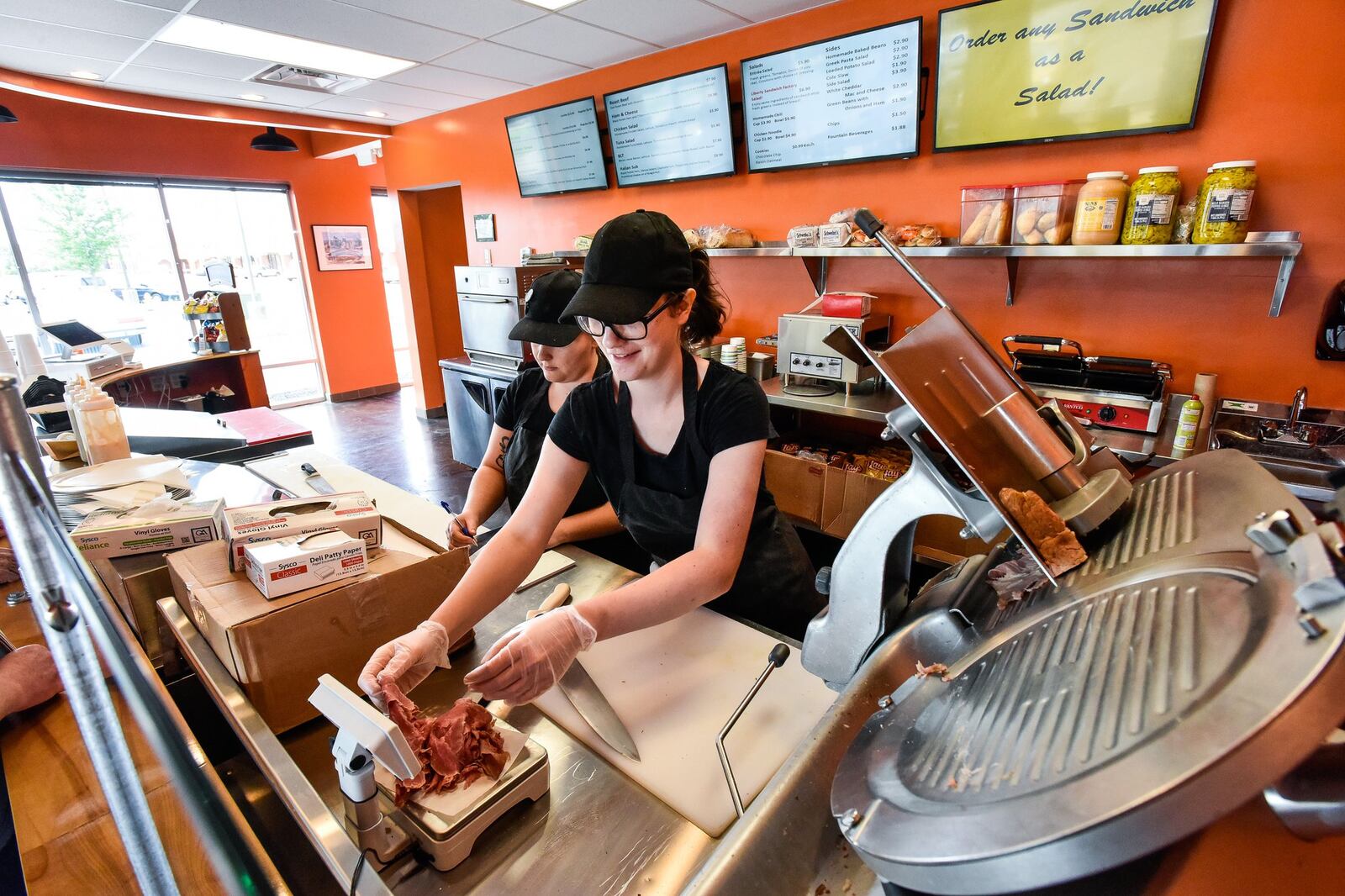 Assistant manager Alyssa Price, left, and Jillian Becker prepare sandwiches and Liberty Sandwich Factory Friday, July 6 in Liberty Township. The restaurant features homemade corned beef, hand-carved turkey sandwiches, a homemade Cuban sandwich with fresh pork and traditional staples such as ham-and-cheese sandwiches, turkey-and-cheese sandwiches and other deli meats and cheeses. The menu also will feature homemade baked beans, soups, chili, macaroni and cheese and more. NICK GRAHAM/STAFF