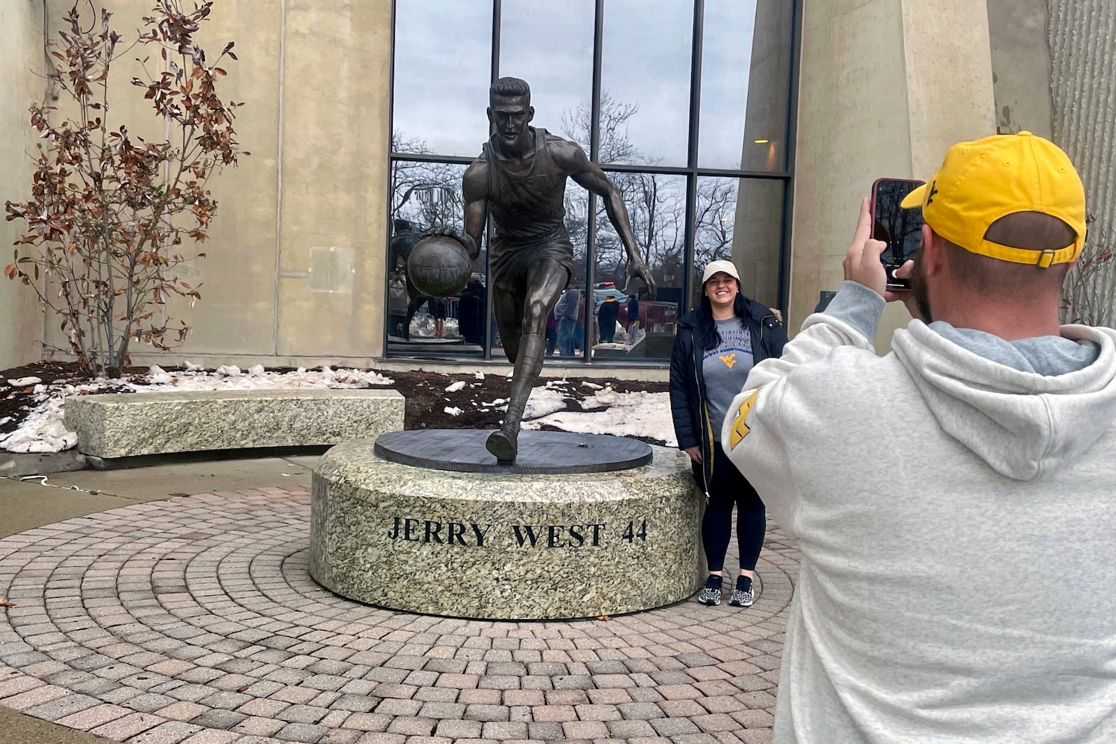 Fans take photos with the statue honoring NBA great Jerry West, stands outside the West Virginia University Coliseum, in Morgantown, W.Va., Saturday, Jan. 18, 2025, as fans arrive for an NCAA college basketball game between Iowa State and West Virginia. (AP Photo/John Raby)