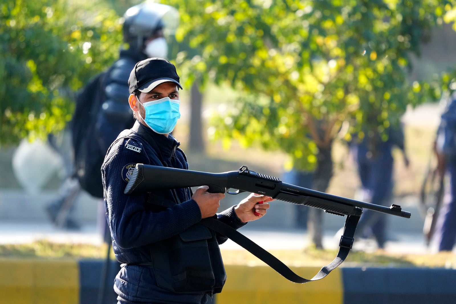 A police officer loads his riffle with rubber bullets during clashes with supporters of imprisoned former Premier Imran Khan's Pakistan Tehreek-e-Insaf party, in Islamabad, Pakistan, Tuesday, Nov. 26, 2024. (AP Photo/Anjum Naveed)