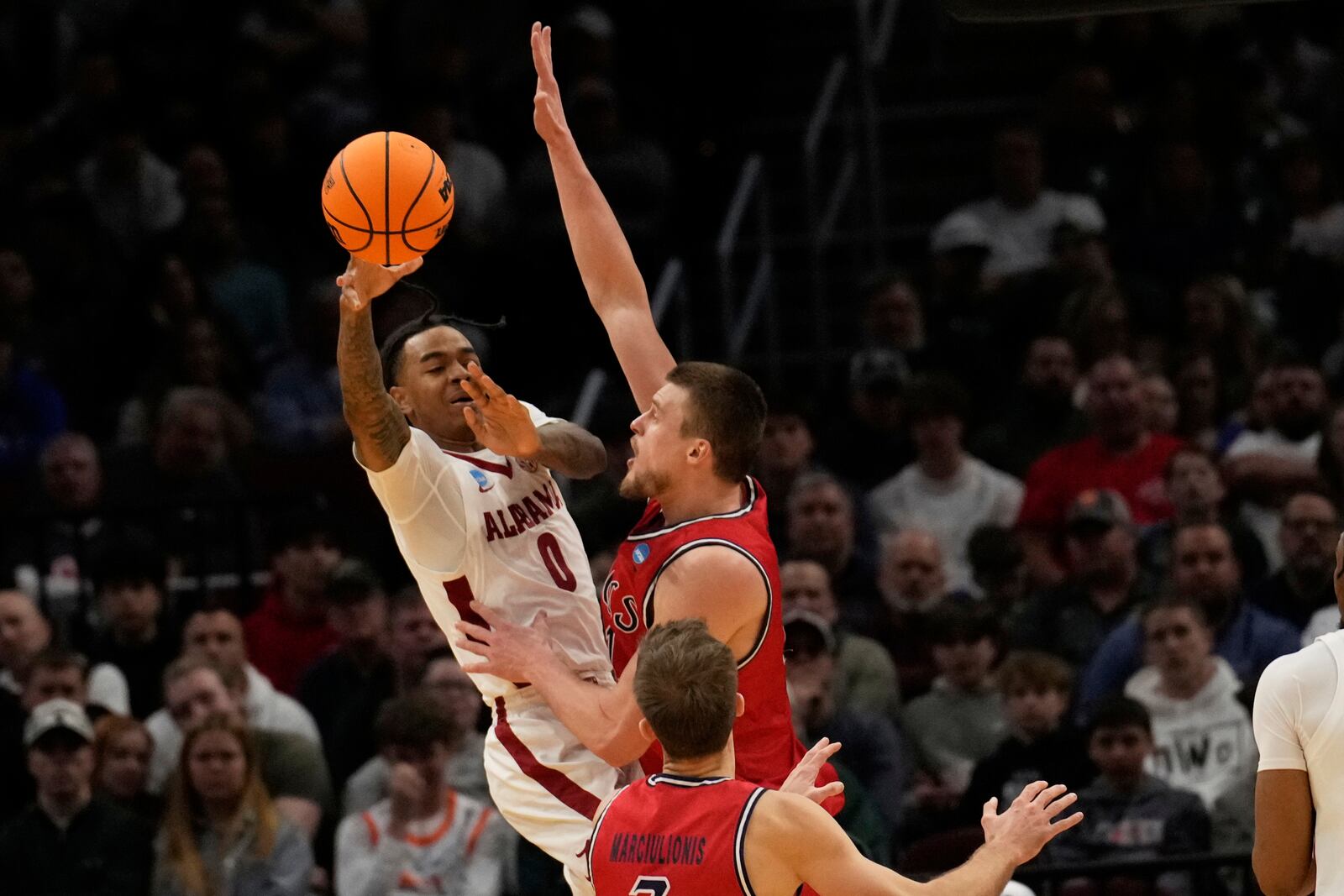 Alabama guard Labaron Philon (0) passes in front of Saint Mary's center Mitchell Saxen, right, and guard Augustas Marciulionis, center, in the second half in the second round of the NCAA college basketball tournament, Sunday, March 23, 2025, in Cleveland. (AP Photo/Sue Ogrocki)