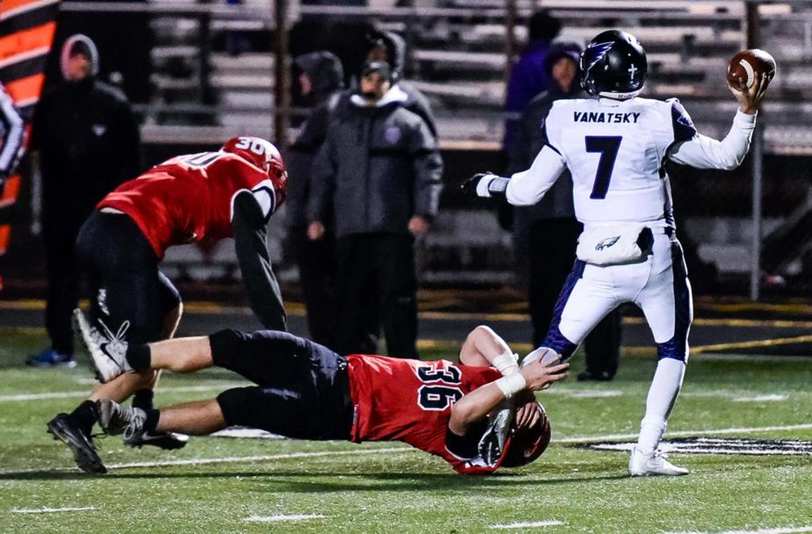 Madison’s Cole Pelgen (36) gets a grip on Cincinnati Hills Christian Academy quarterback Danny Vanatsky as MHS teammate Levi McMonigle helps out Friday night during a Division V, Region 20 semifinal at Lakota East. NICK GRAHAM/STAFF