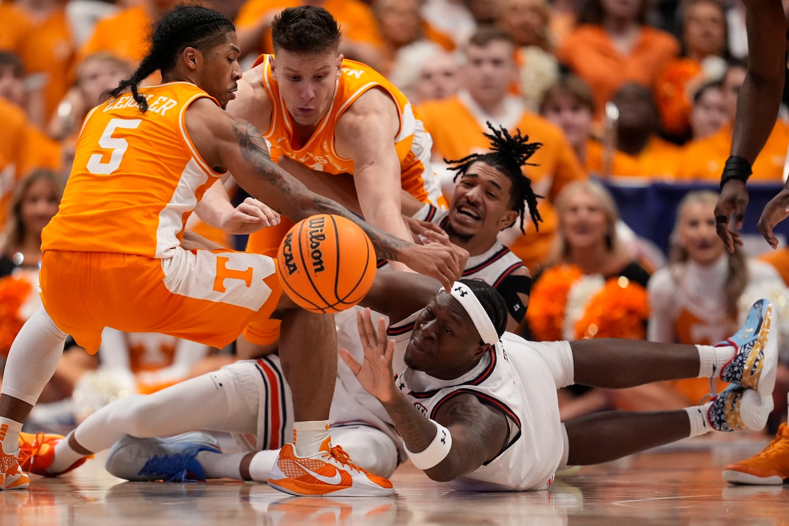 Auburn forward Ja'Heim Hudson, right bottom and Tennessee guard Zakai Zeigler (5) chase a loose ball during the first half of an NCAA college basketball game in the semifinal round of the Southeastern Conference tournament, Saturday, March 15, 2025, in Nashville, Tenn. (AP Photo/George Walker IV)