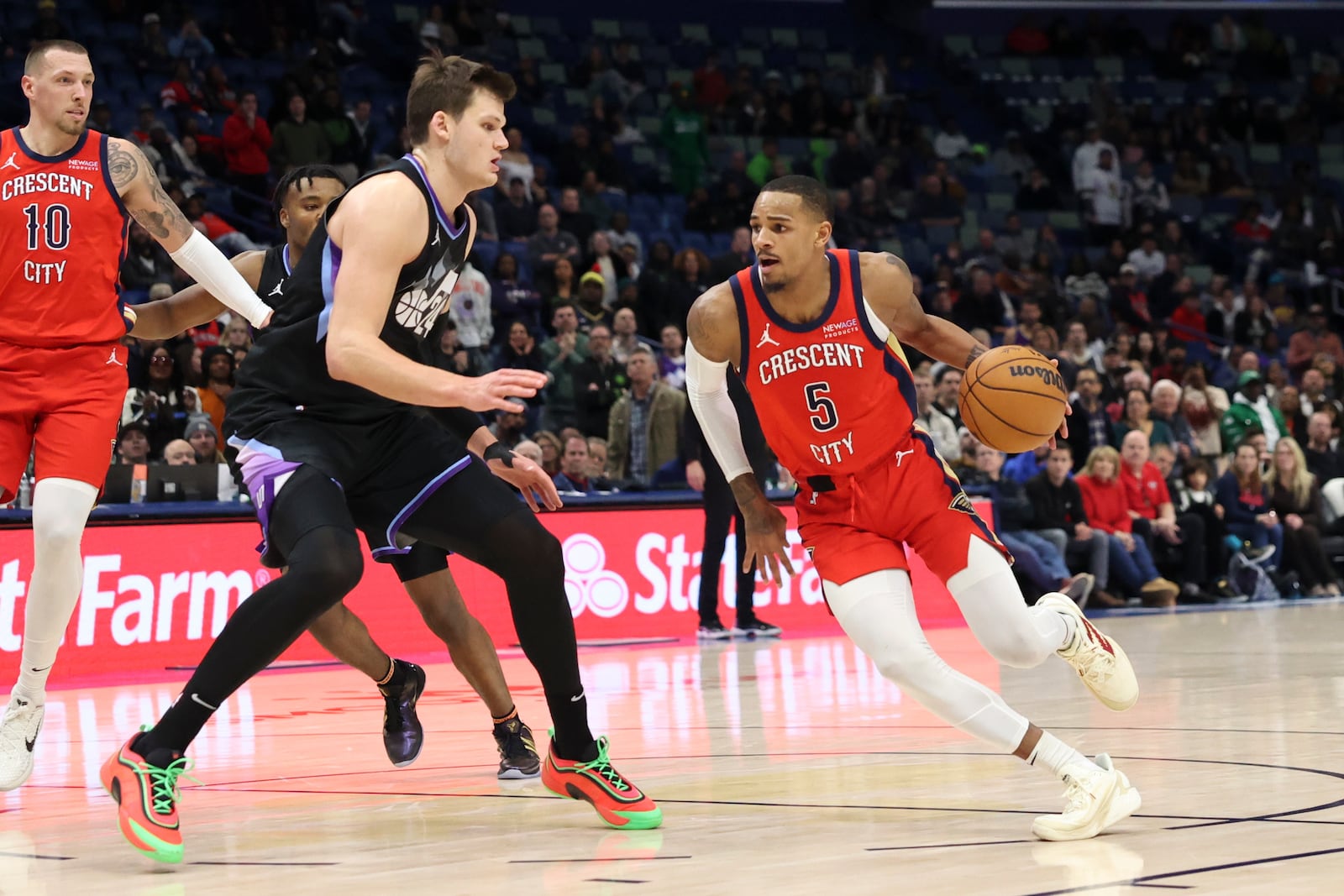 New Orleans Pelicans guard Dejounte Murray (5) drives to the basket against Utah Jazz center Walker Kessler, front left, in the second half of an NBA basketball game in New Orleans, Monday, Jan. 20, 2025. (AP Photo/Peter Forest)