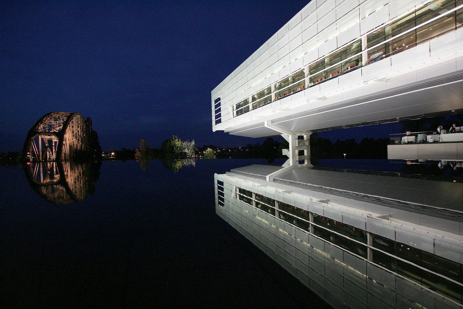 FILE - Lights reflect off a railroad bridge on the grounds of Bill Clinton's presidential library as the lighted center is reflected in a fountain, Nov. 17, 2004, in Little, Rock, Ark., the night before the grand opening. (AP Photo/Ric Feld, File)