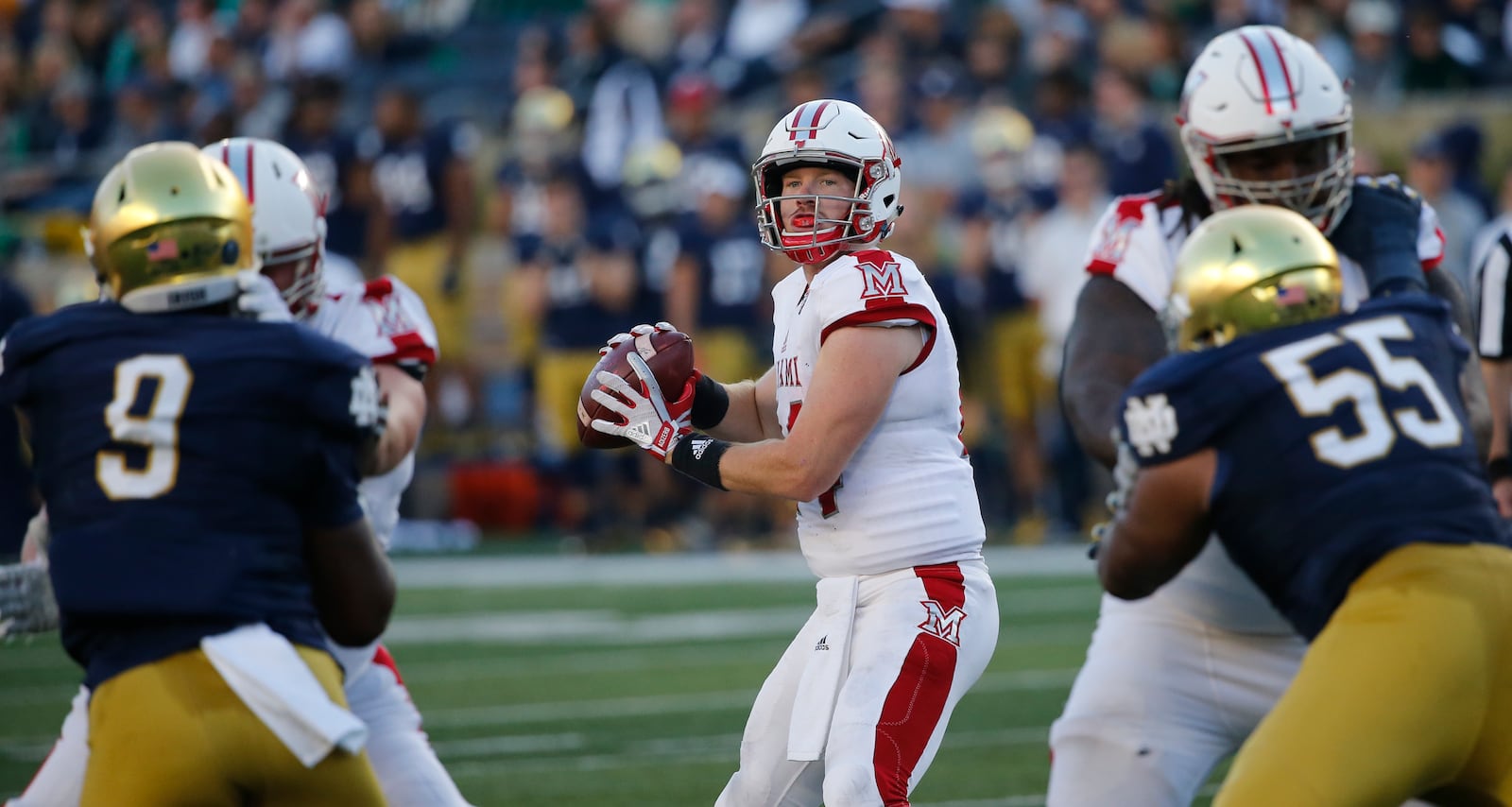 Miami quarterback Gus Ragland drops back to pass as Notre Dame’s Daelin Hayes (9) and Jonathan Bonner (55) rush Saturday night during the Fighting Irish’s 52-17 triumph at Notre Dame Stadium in Notre Dame, Ind. CHARLES REX ARBOGAST/ASSOCIATED PRESS