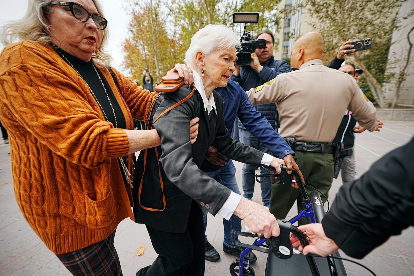 Erik and Lyle Menendez's aunt Joan VanderMolen, center, is assisted by Karen VanderMolen, as they arrive to attend a hearing at the Van Nuys courthouse in Los Angeles, Monday, Nov. 25, 2024. (AP Photo/Damian Dovarganes)