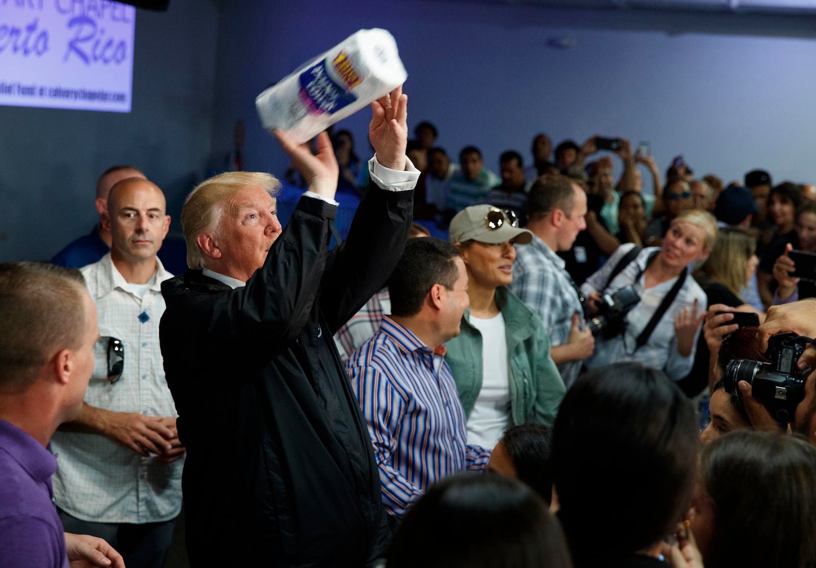 FILE - President Donald Trump tosses paper towels into a crowd at Calvary Chapel in Guaynabo, Puerto Rico, Oct. 3, 2017. (AP Photo/Evan Vucci, File)