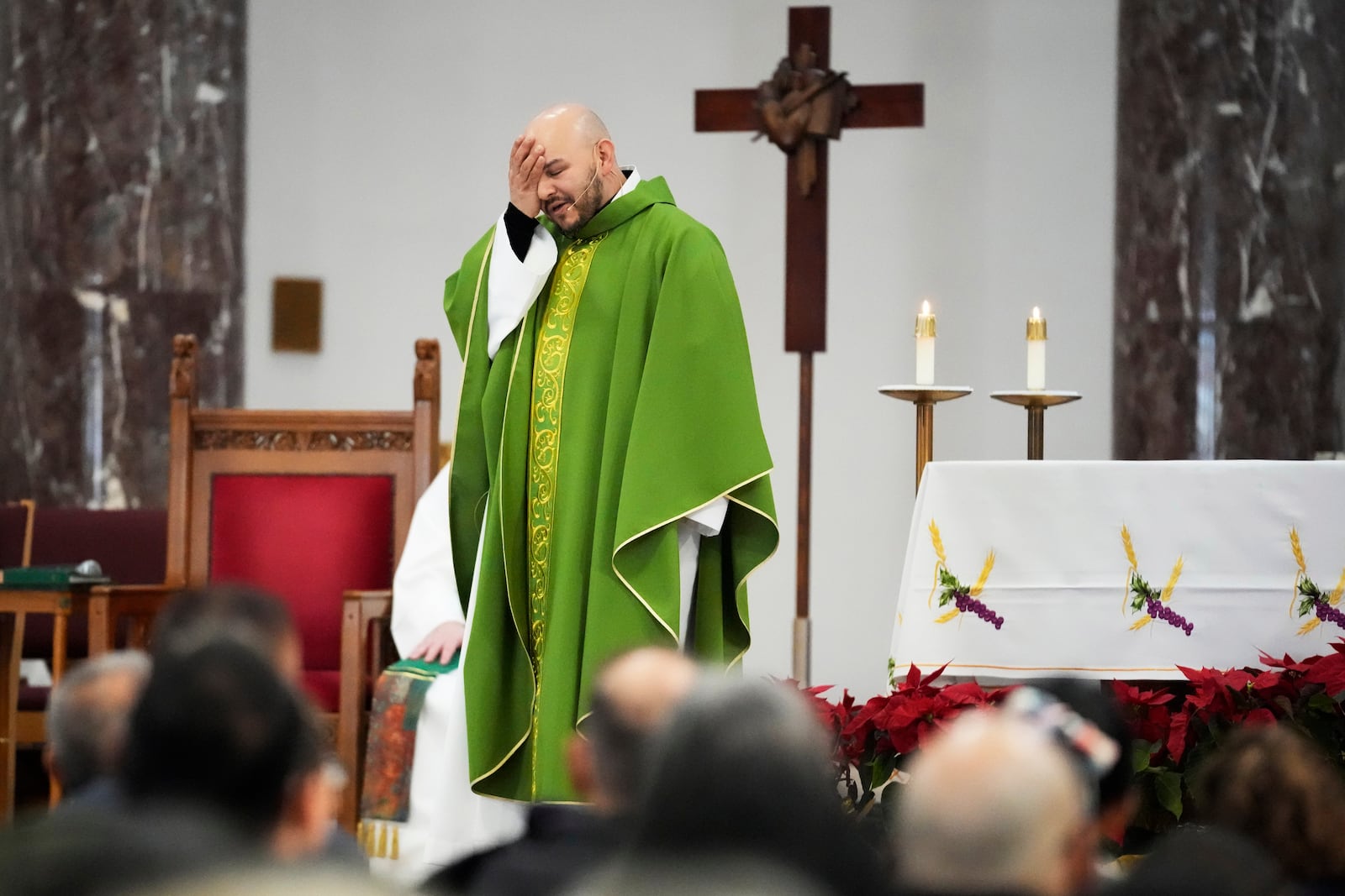 Priest Homero Sanchez reacts as he speaks during a service at St. Rita of Cascia Parish in Chicago, Sunday, Jan. 19, 2025. (AP Photo/Nam Y. Huh)