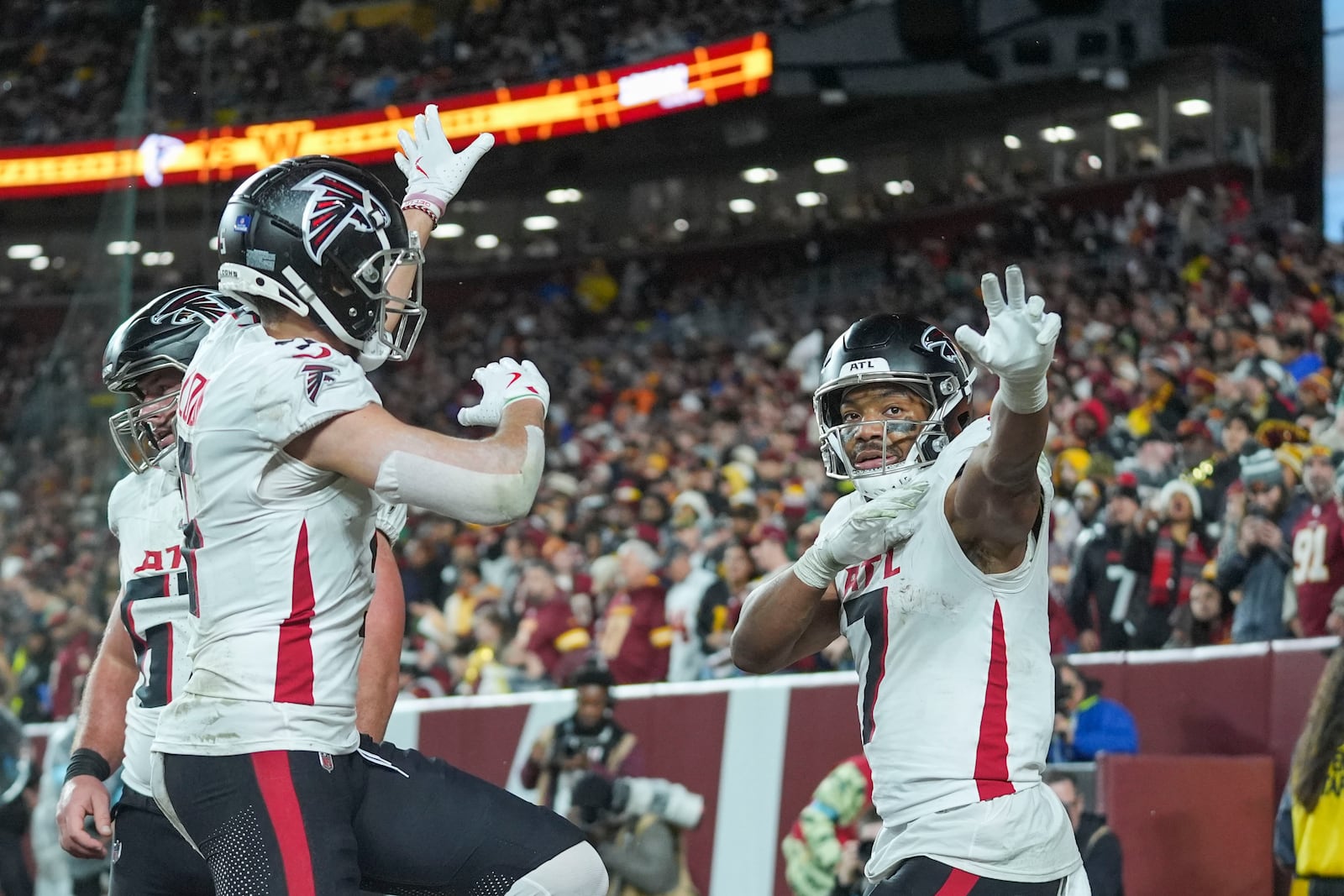 Atlanta Falcons running back Bijan Robinson (7) celebrates his touchdown with wide receiver Drake London during the first half of an NFL football game against the Washington Commanders, Sunday, Dec. 29, 2024, in Landover. (AP Photo/Stephanie Scarbrough)