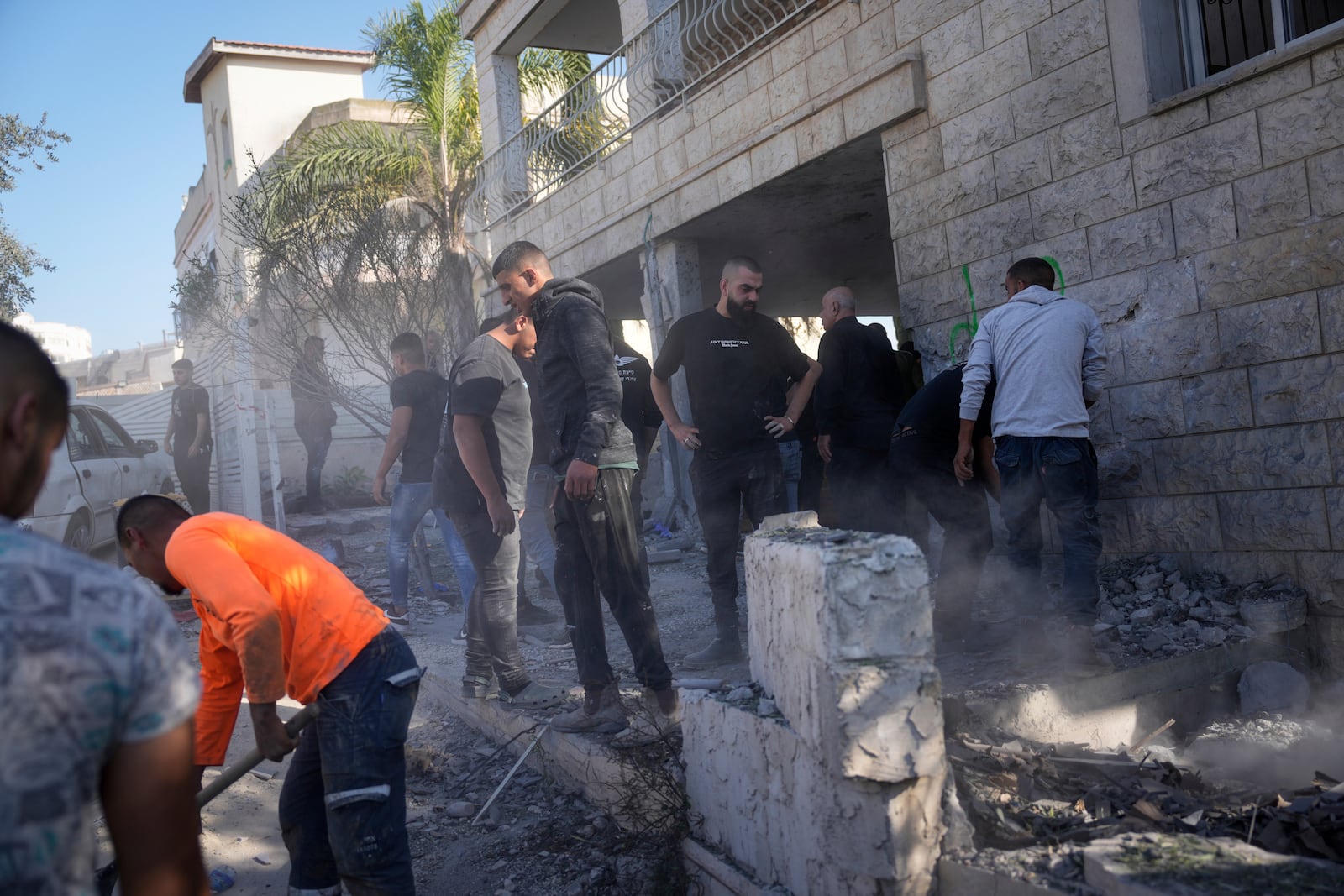 People examine a damaged house where one person was killed after a projectile launched from Lebanon slammed into Maalot-Tarshiha, northern Israel, Tuesday, Oct. 29, 2024. (AP Photo/Ohad Zwigenberg)