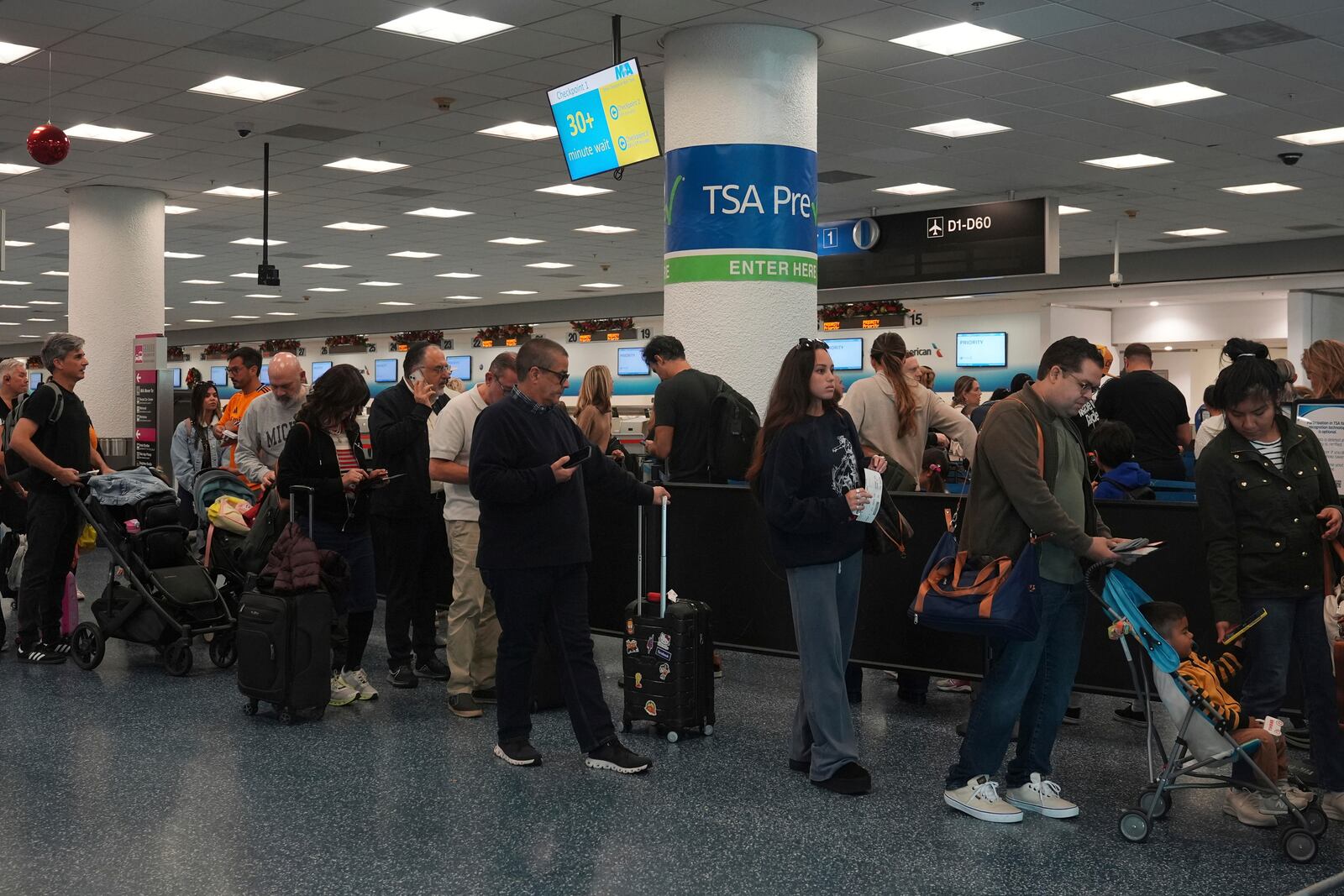 Passengers wait to check-in at Miami International Airport, Tuesday, Nov. 26, 2024, in Miami. (AP Photo/Marta Lavandier)