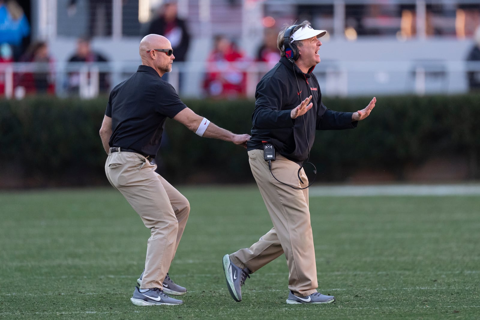 Georgia head coach Kirby Smart, right, is restrained by an assistant as he yells instructions to his players on the field during the second half of an NCAA college football game against UMass, Saturday, Nov. 23, 2024, in Athens, Ga. (AP Photo/John Bazemore)