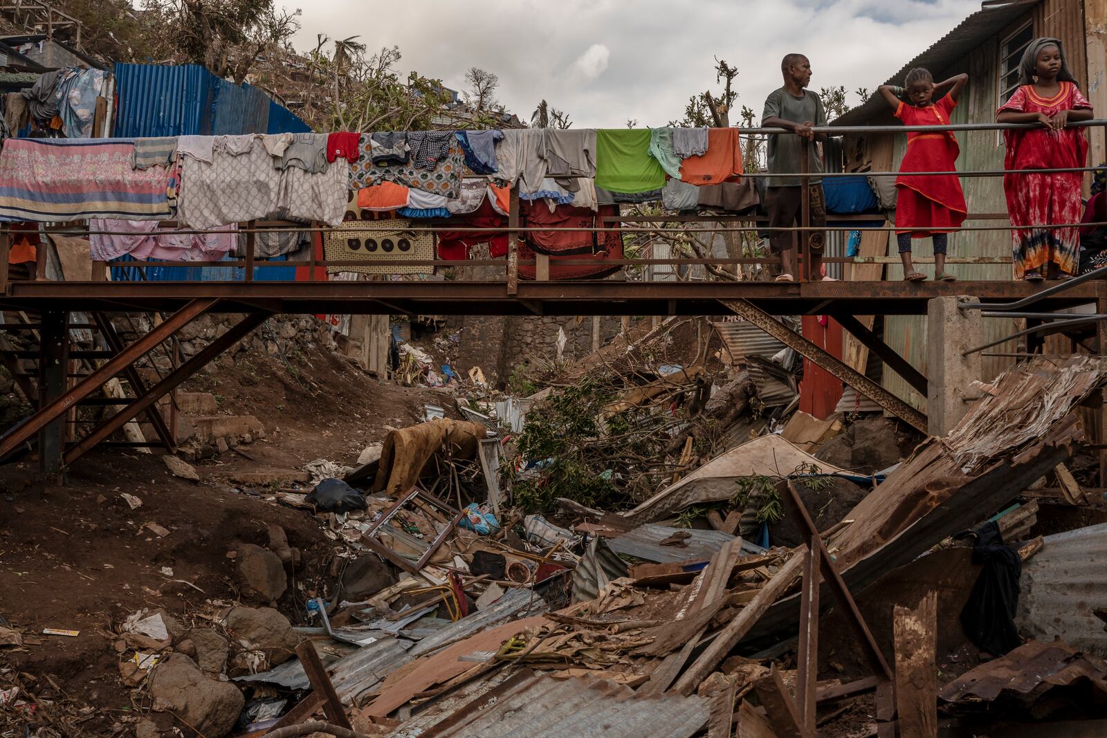 Debris litters a stream in the Kaweni slum in the French Indian Ocean island of Mayotte, Thursday, Dec. 19, 2024, after Cyclone Chido.. (AP Photo/Adrienne Surprenant))