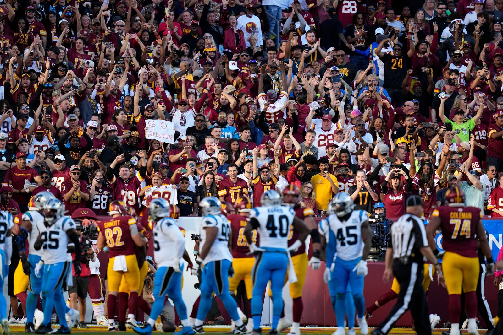 Washington Commanders fans celebrate after a touchdown run by Commanders running back Brian Robinson Jr. during the first half of an NFL football game against the Carolina Panthers, Sunday, Oct. 20, 2024, in Landover, Md. (AP Photo/Stephanie Scarbrough)