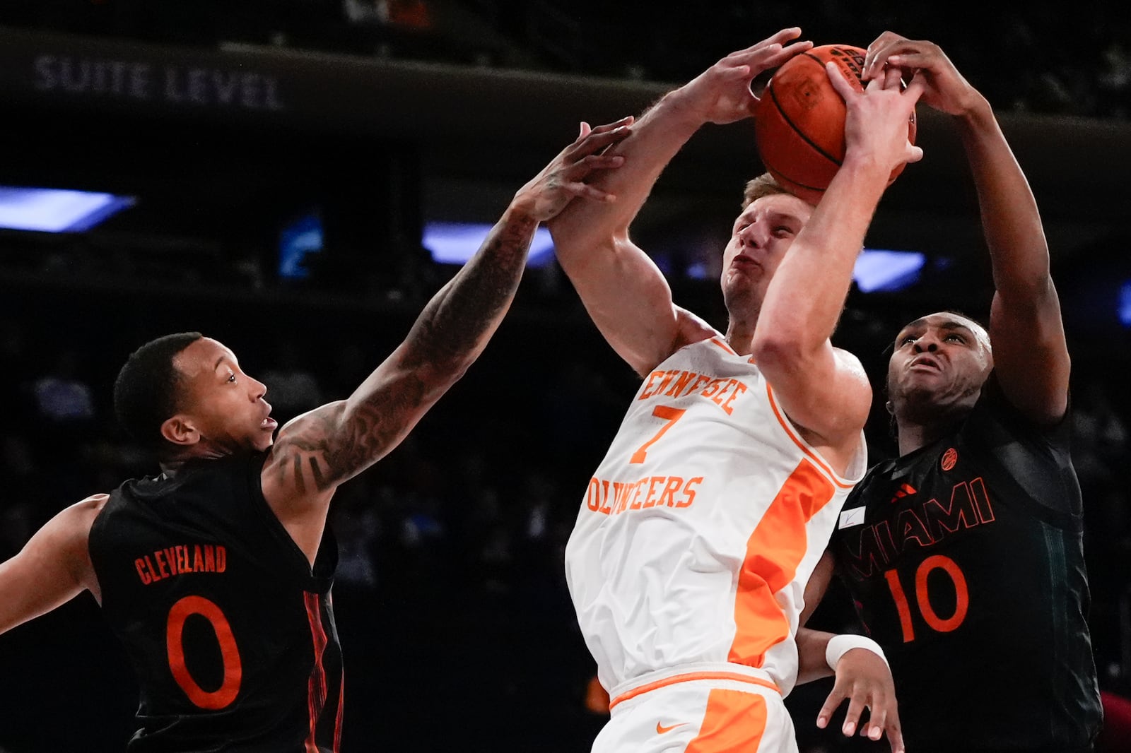 Miami guard Matthew Cleveland (0) Tennessee forward Igor Milicic Jr. (7) and Miami guard Paul Djobet (10) reach for the ball during the first half of an NCAA college basketball game, Tuesday, Dec. 10, 2024, in New York. (AP Photo/Julia Demaree Nikhinson)