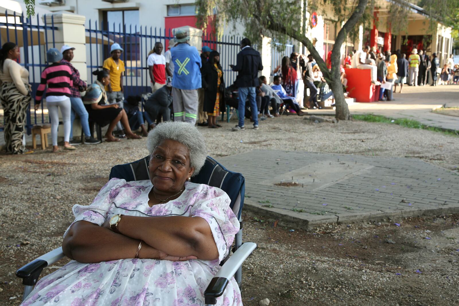 A woman sits as Namibians queue to cast their votes in a presidential election in Windhoek, Namibia Wednesday, Nov. 27, 2024. (AP Photo/Dirk Heinrich)