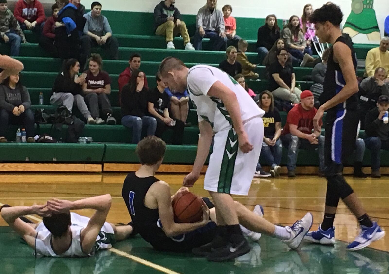 New Miami’s Nate Hobbs (left) and Cincinnati Christian’s Riley Reutener (1) are down in the lane during Tuesday night’s game at NM. The Vikings’ Ronnie Bowman is providing some assistance to Reutener as the Cougars’ Jalon Percy comes in late to the play. RICK CASSANO/STAFF