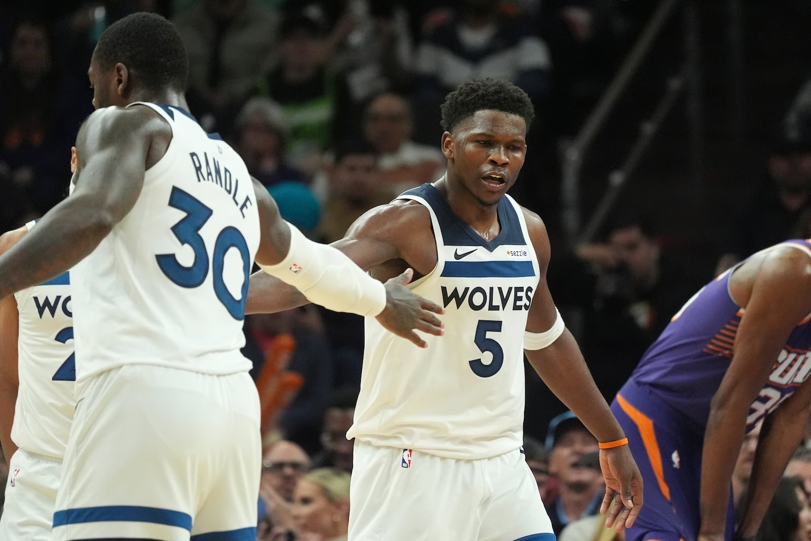 Minnesota Timberwolves guard Anthony Edwards (5) celebrates his score against the Phoenix Suns with Timberwolves forward Julius Randle (30) during the second half of an NBA basketball game Wednesday, Jan. 29, 2025, in Phoenix. The Timberwolves won 121-113. (AP Photo/Ross D. Franklin)