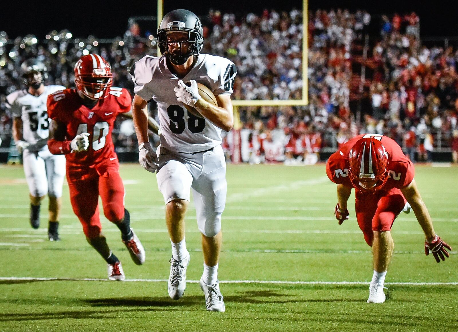 Lakota East’s Evan Yablonsky scores on a pass from Dylan Fry, getting past Fairfield’s Nashon Bell (40) and Kyle Schimpf (2) during Friday night’s game at Fairfield Stadium. NICK GRAHAM/STAFF