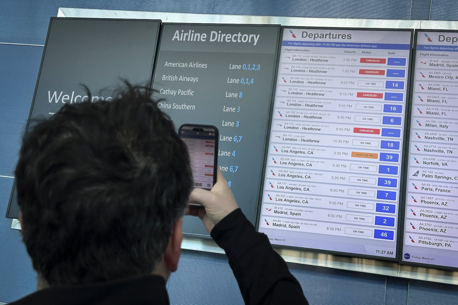 Cancellations for British Airways flights to London Heathrow airport are displayed as cancelled on a departures board at JFK International airport, Friday, March 21, 2025, in New York. (AP Photo/John Minchillo)